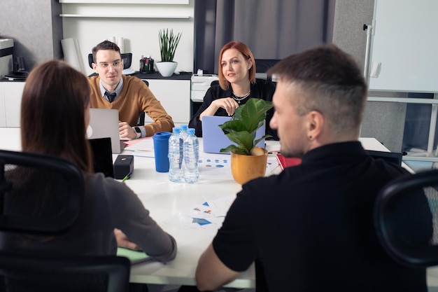 Een team van kantoormedewerkers aan tafel die nieuwe projecten bespreekt