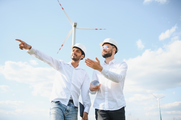 Een team van mannelijke ingenieurs die samenwerken op het windturbine-generatorpark