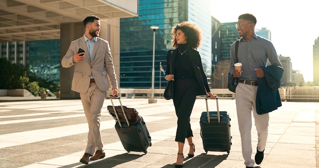 Foto een team van zakenmensen loopt en reist met een koffer in de stad voor zakelijke baankansen en netwerken professionele vrouw en mannen praten in een openluchthotel of op weg naar de luchthaven met bagage