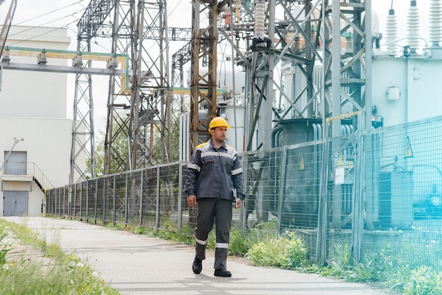 Een technisch medewerker maakt een rondleiding en inspectie van een modern elektrisch onderstation. Energie. Industrie.