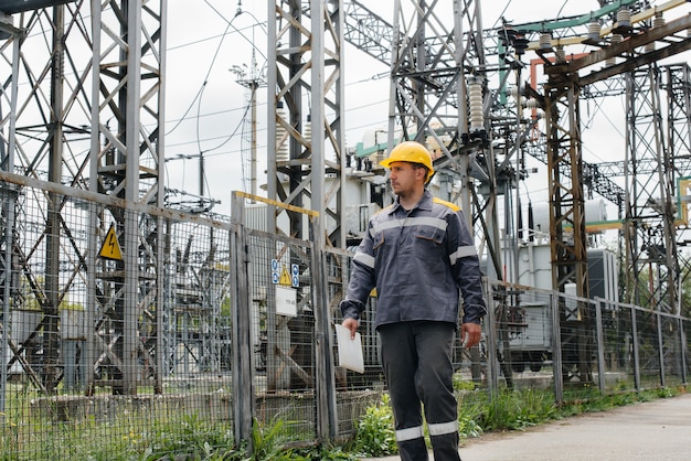 Een technische medewerker maakt een rondleiding en inspectie van een modern elektrisch onderstation. Energie. Industrie.