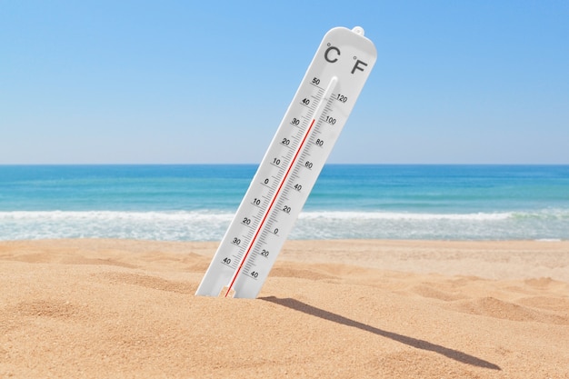 Een thermometer op het strand bij de zee om de temperatuur te controleren.