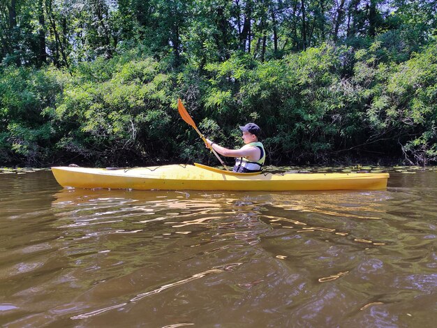 Een tiener kajakt op de rivier in een reddingsvest en oefent actief leven en rust