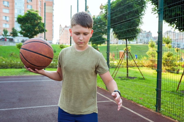 Een tiener met een basketbal op het veld