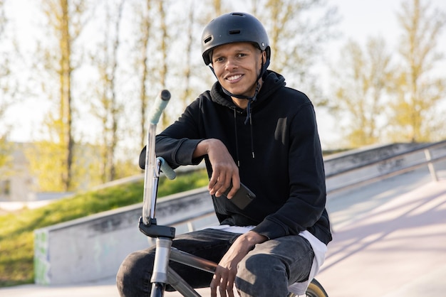 Een tiener wacht na school met zijn fiets op klasgenoten in het skatepark