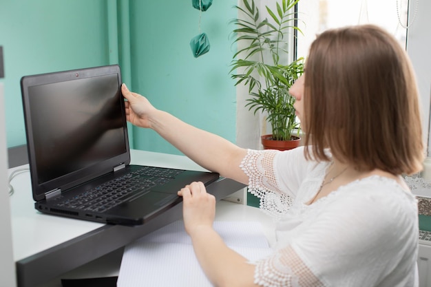 Een tiener zit voor een laptop met de bedoeling om online te leren leven