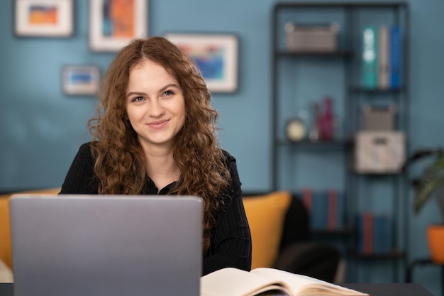 Een tienermeisje is blij een e-mail te ontvangen Een studente zit aan haar bureau in de woonkamer