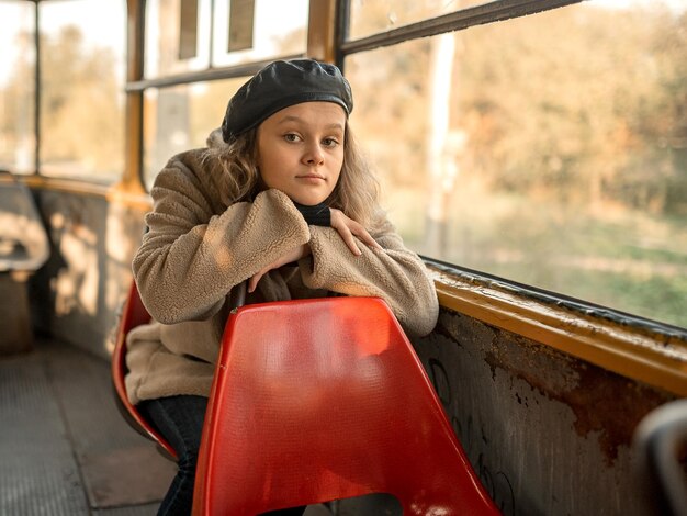 Foto een tienermeisje zit in een tram in een bontjas, pakt hem en gaat op zakenreis