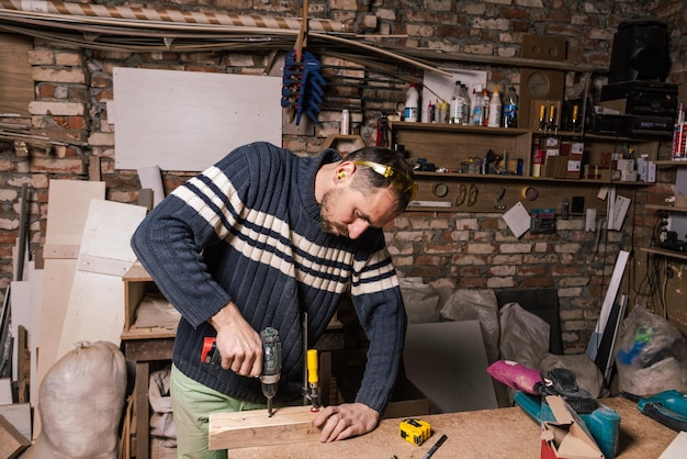 Foto een timmerman werkt in een meubelwerkplaats met diverse gereedschappen en een bord