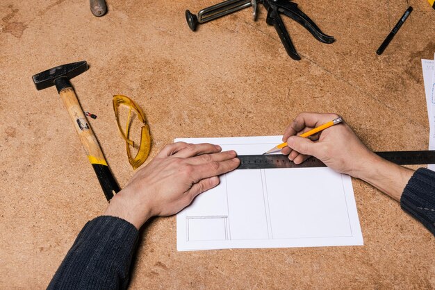 Een timmerman werkt in een meubelwerkplaats met diverse gereedschappen en een bord