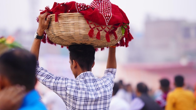 Een toegewijde draagt pooja of aanbiddingsartikelen voor Chhath Puja