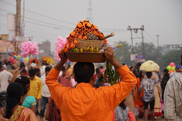 Een toegewijde draagt pooja of aanbiddingsartikelen voor Chhath Puja