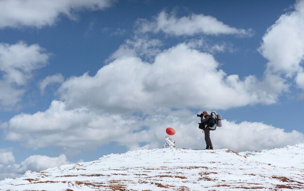 Een toerist kijkt naar het landschap. Fotograaf bovenop de berg. Lente landschap. Karpaten, Oekraïne, Europa