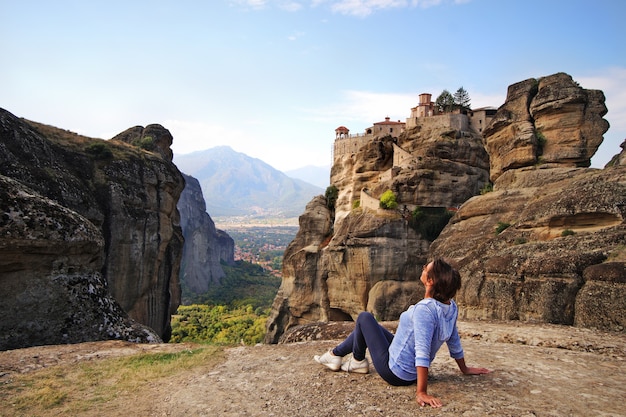 Een toerist ontspant en bewondert het adembenemende uitzicht in Meteora