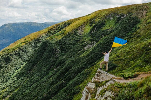 Een toerist op de bergen met een Oekraïense vlag