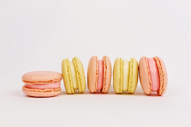 Een toren van veelkleurige bitterkoekjes op een effen witte achtergrond