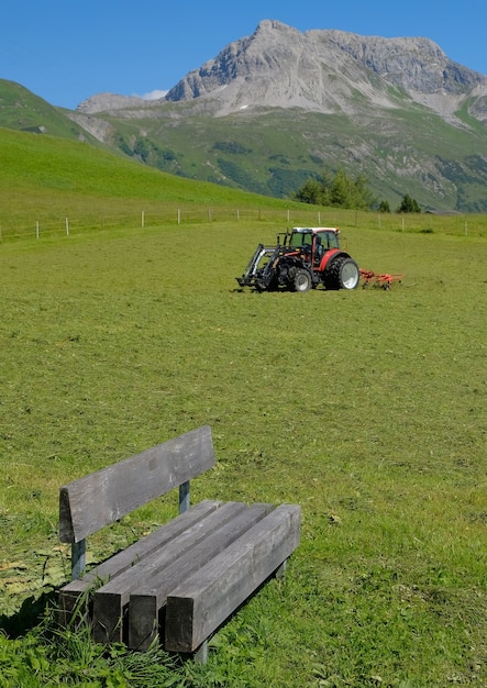 Een tractor aan het werk in de velden hoog in de alpenbergen van oostenrijk