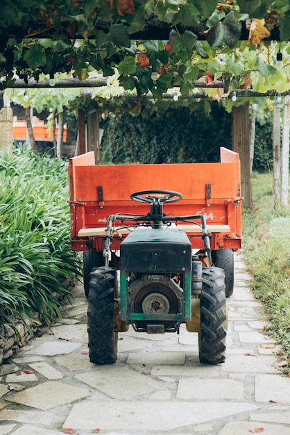 een tractor met een aanhangwagen er aan bevestigd die het woord aan de zijkant zegt