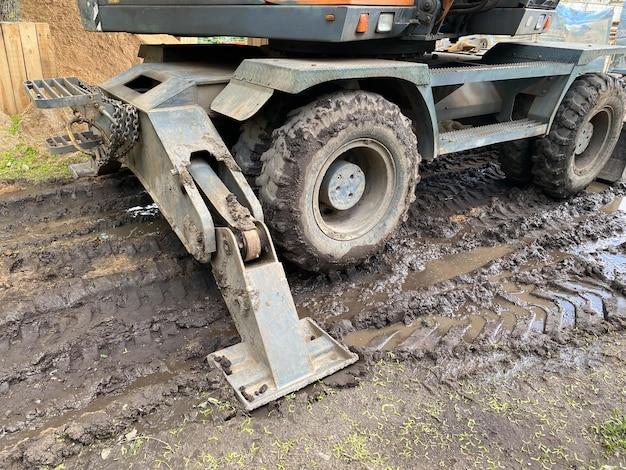 Een tractor met grote zwarte wielen in de modder grote bouwmachines voor de bouw