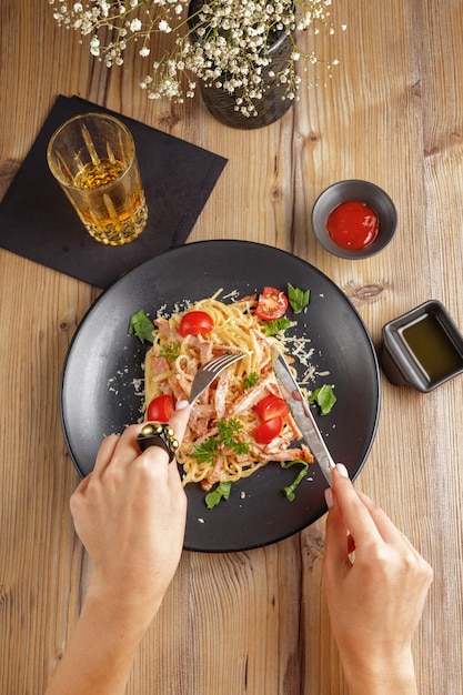Een traditioneel gerecht van een Italiaans pastarestaurant met een houten tafel met zwarte plaat