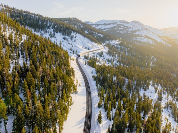 Een trein rijdt door een besneeuwd berglandschap.