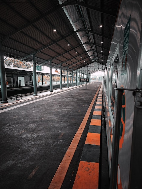 Een trein staat geparkeerd bij een treinstation met een groene streep met "het woord" op de zijkant. "