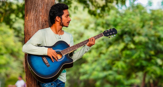 Een trieste jongen die gitaar speelt