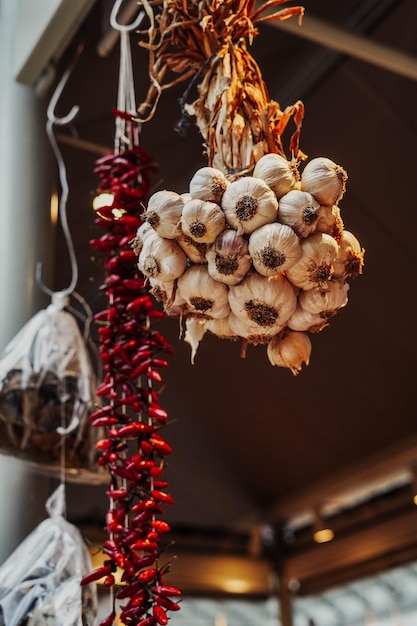 Een tros knoflook en een tros hete cayennepeper hangend aan een Argentijnse rotisserie.