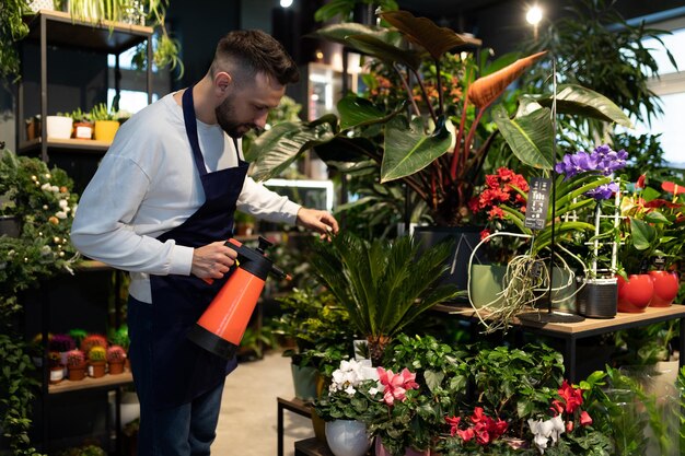 Een tuinman in een plantenkwekerij die bloemen verzorgt