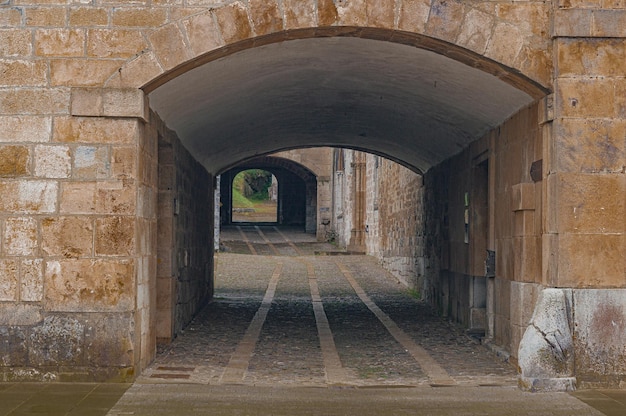 Een tunnel met een bakstenen muur met een bakstenen boog waarop staat 'de brug'