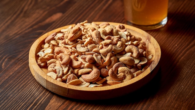 Een uitstekende biersnack is zoute cashewnoten in een houten bord.