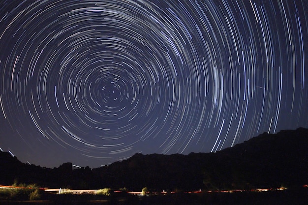 Een uitzicht op de sterren van de Melkweg met een bergtop op de voorgrond Perseïden meteorenbuien waarneming