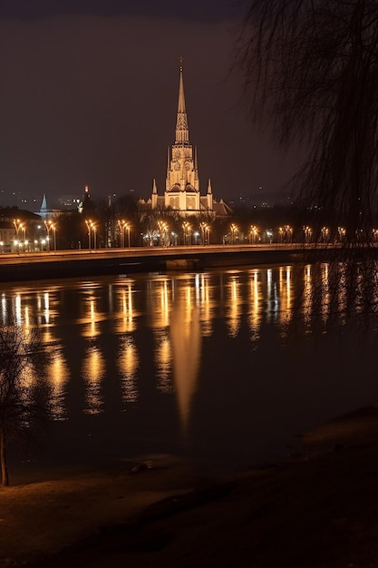 Een uitzicht op een rivier met een kerktoren 's nachts.