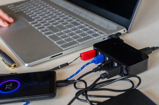 Een USB-splitterapparaat. Zeven poort USB volgende laptop op een bureau. Laad de batterij van de mobiele telefoon op. Selectieve focus.