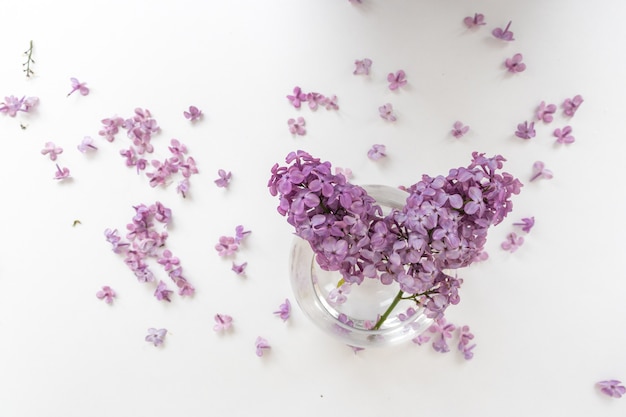 Een vaas water met lila bloemen erin drijvend