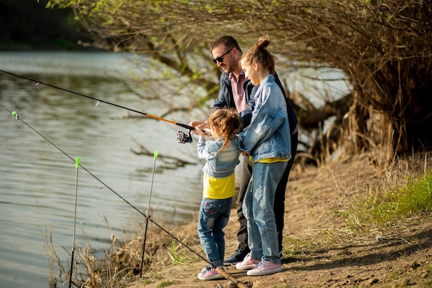 Een vader en zijn twee dochters vissen in de rivier Familievakantie Hobby Lifestile