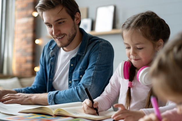 Een vader helpt zijn dochtertje om haar huiswerk voor de school te maken.