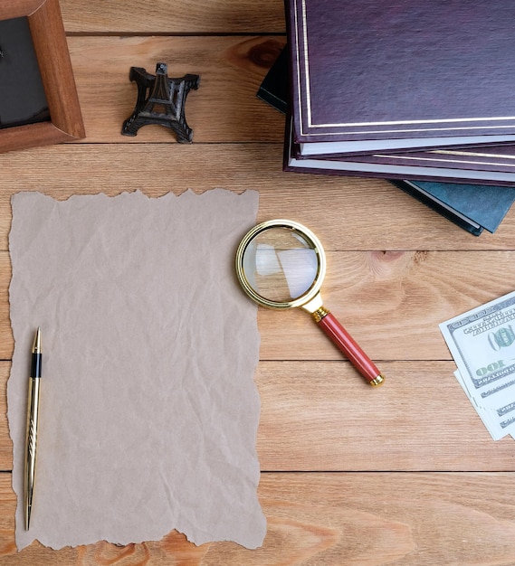 Foto een vel papier, een pen en een vergrootglas op een houten tafel