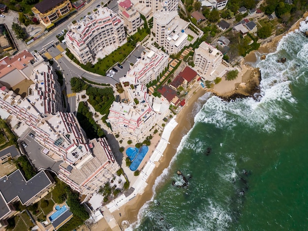 Een verbluffend luchtfoto van een exclusief wooncomplex gelegen aan zee met luxe voorzieningen en adembenemende uitzichten over de oceaan