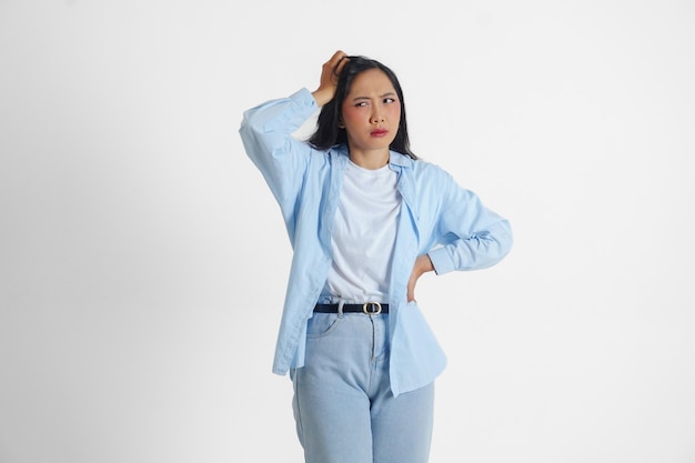 Een verdrietige Aziatische vrouw ziet er gestrest en depressief uit of heeft hoofdpijn geïsoleerde witte achtergrond