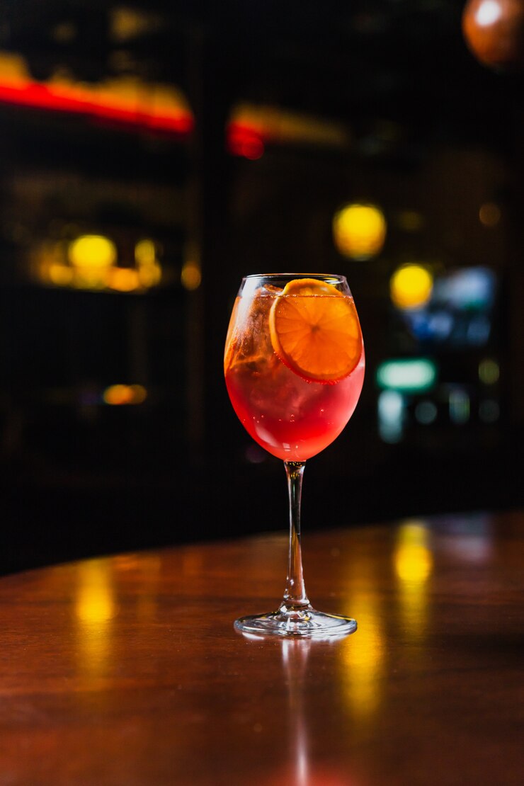 Een verfrissende koude cocktail met ijs en stukjes sinaasappel in een wijnglas