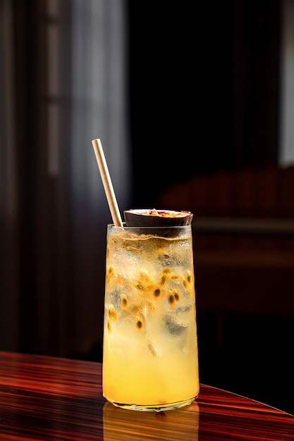 Een verfrissende longdrink met passievrucht in een highball cocktailglas gevuld met ijsblokjes