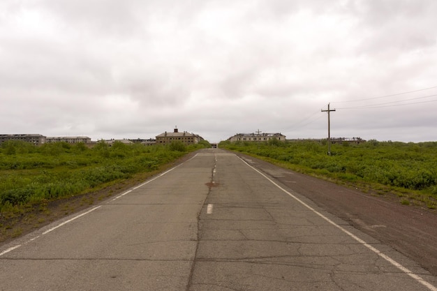 Een verlaten weg die leidt naar de geestennederzetting sovetsky. verlaten stad. vorkoeta, rusland.