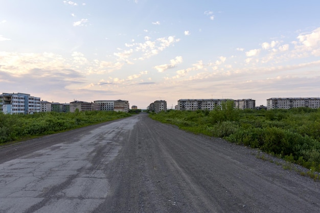 Een verlaten weg naar de verlaten spookstad Komsomolsky, Rusland