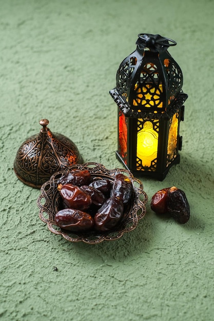 Een verlichte Marokkaanse decoratieve lamp en data in een oud antiek achtergrondconcept van plaatramadan