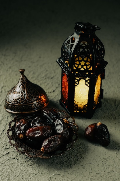 Een verlichte Marokkaanse decoratieve lamp en data in een oud antiek achtergrondconcept van plaatramadan