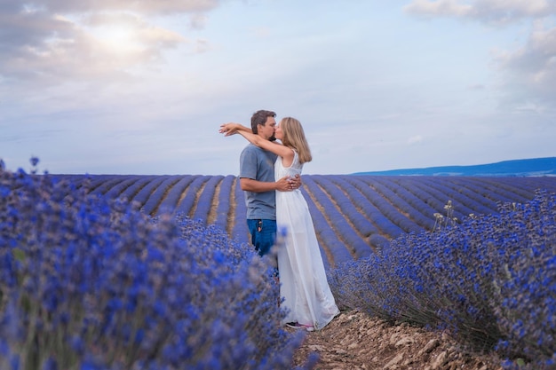 Een verliefd stel loopt door een bloemenweide liefde en lente bloeiend een man omhelst een vrouw