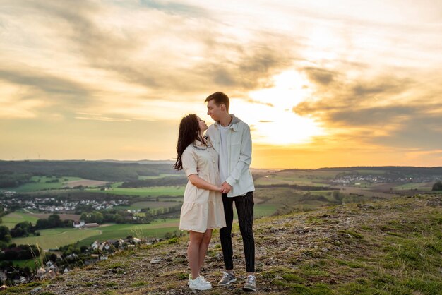 Een verliefd stel staat op een berg bij zonsondergang