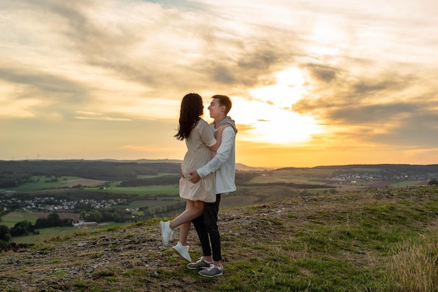 Een verliefd stel staat op een berg bij zonsondergang