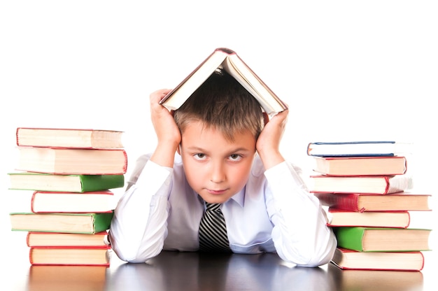 Een vermoeide, achterblijvende schooljongen zit in een bibliotheek met boeken en leert lessen. Onwil om te leren.